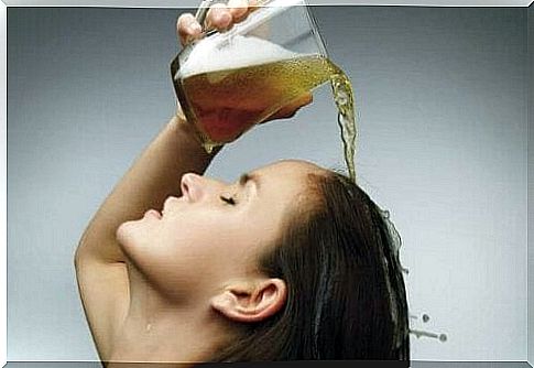 Woman pours beer on her hair