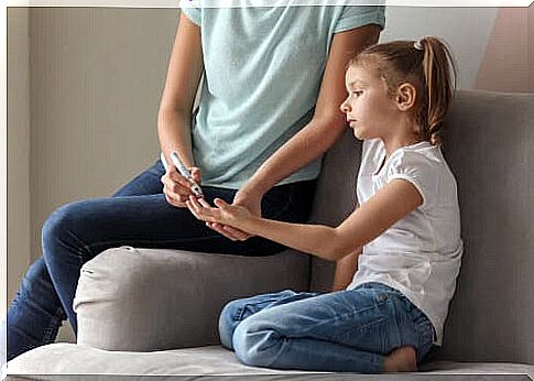 Mother measures her daughter's blood sugar