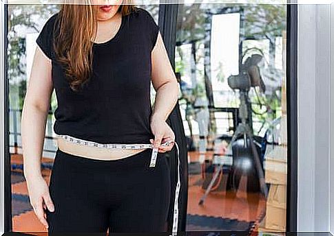 Woman measuring her belly.