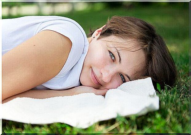 Cheerful girl lying on the meadow