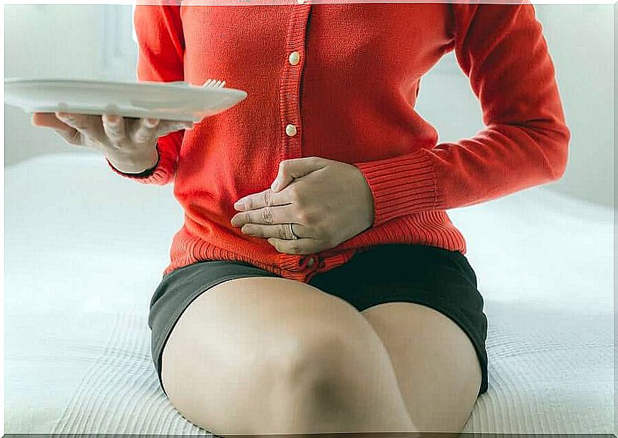 Woman with plate and hand on stomach