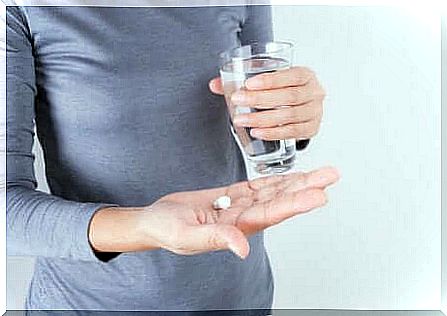 Woman with glass of water and tablet.