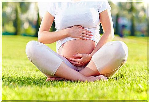 Pregnant woman sitting at the park