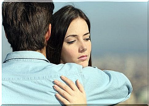 Pensive woman hugs man