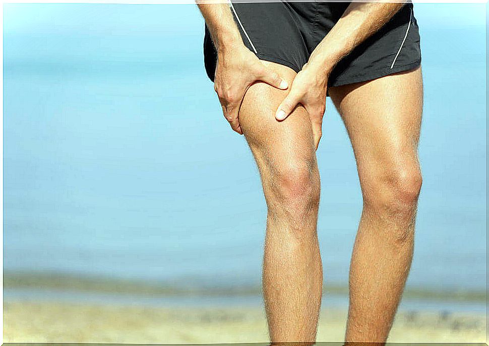 Man at the beach with a cramp