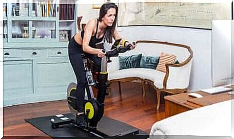 Treating varicose veins: woman using the exercise bike at home.