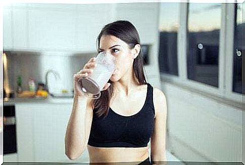 Woman drinking a smoothie to eat before running.